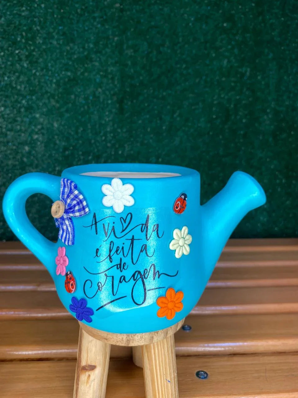 Regadores decorativos com frases inspiradoras usados como vasos personalizados para plantas e suculentas, perfeitos para decorar com significado.